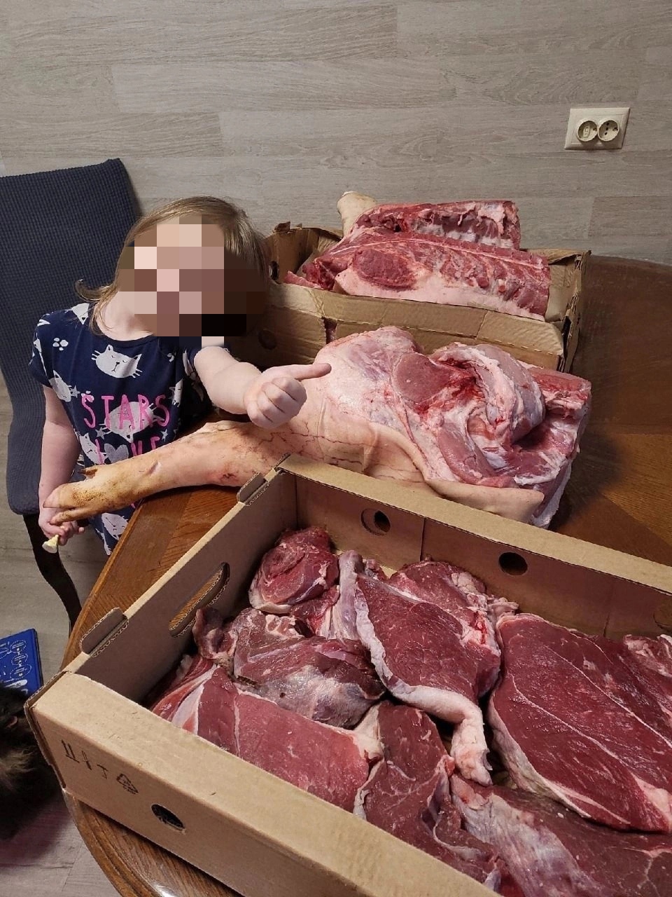 Ради рекламы маленькую девочку сфотографировали с четвертью свиной туши
